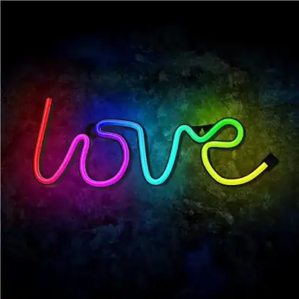 Neón de colores que forma la palabra "love" en un fondo oscuro.